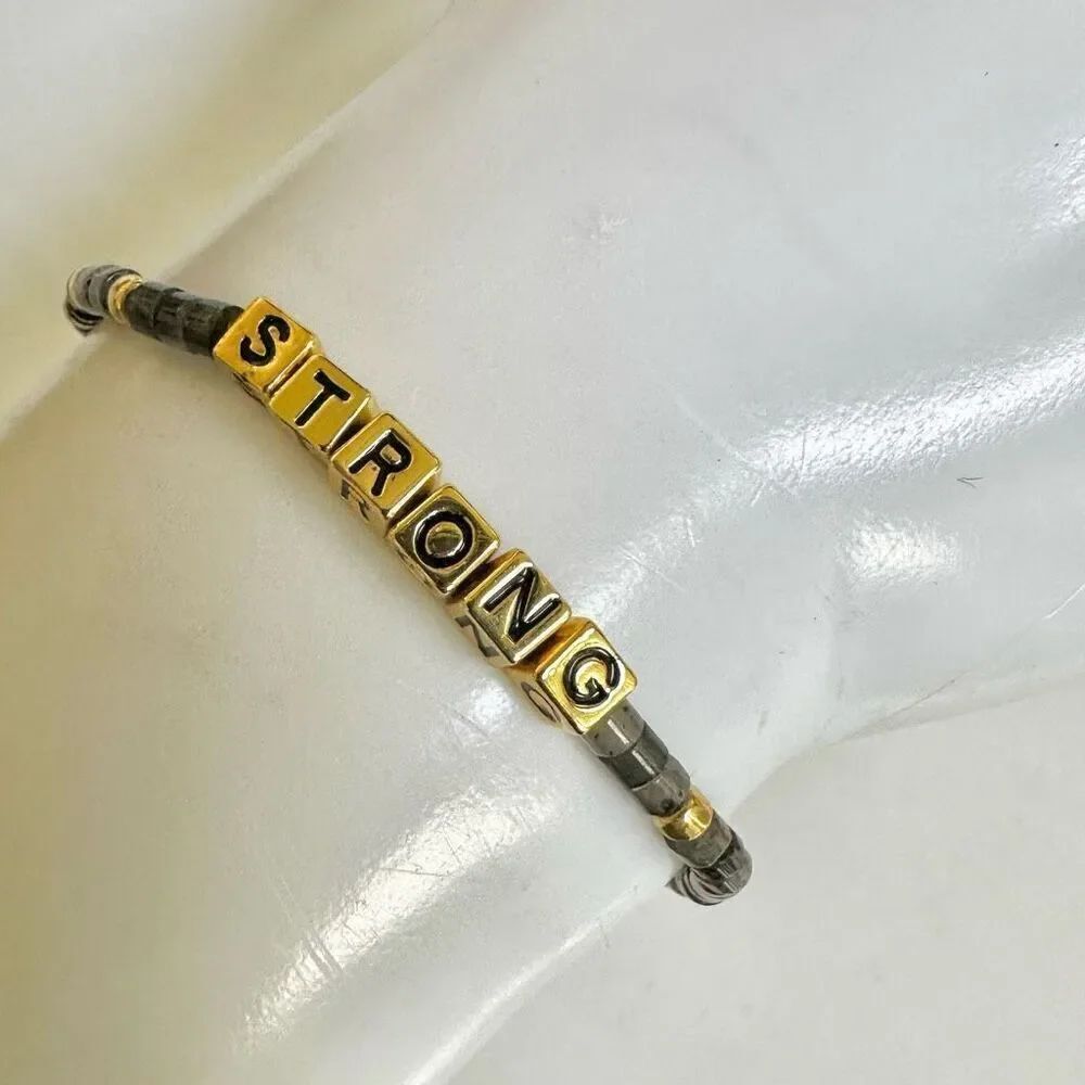 Grey and gold tone STRONG bracelet